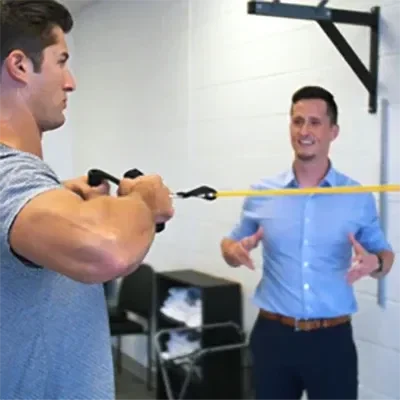 A patient doing exercise therapy while being encouraged by a practitioner
